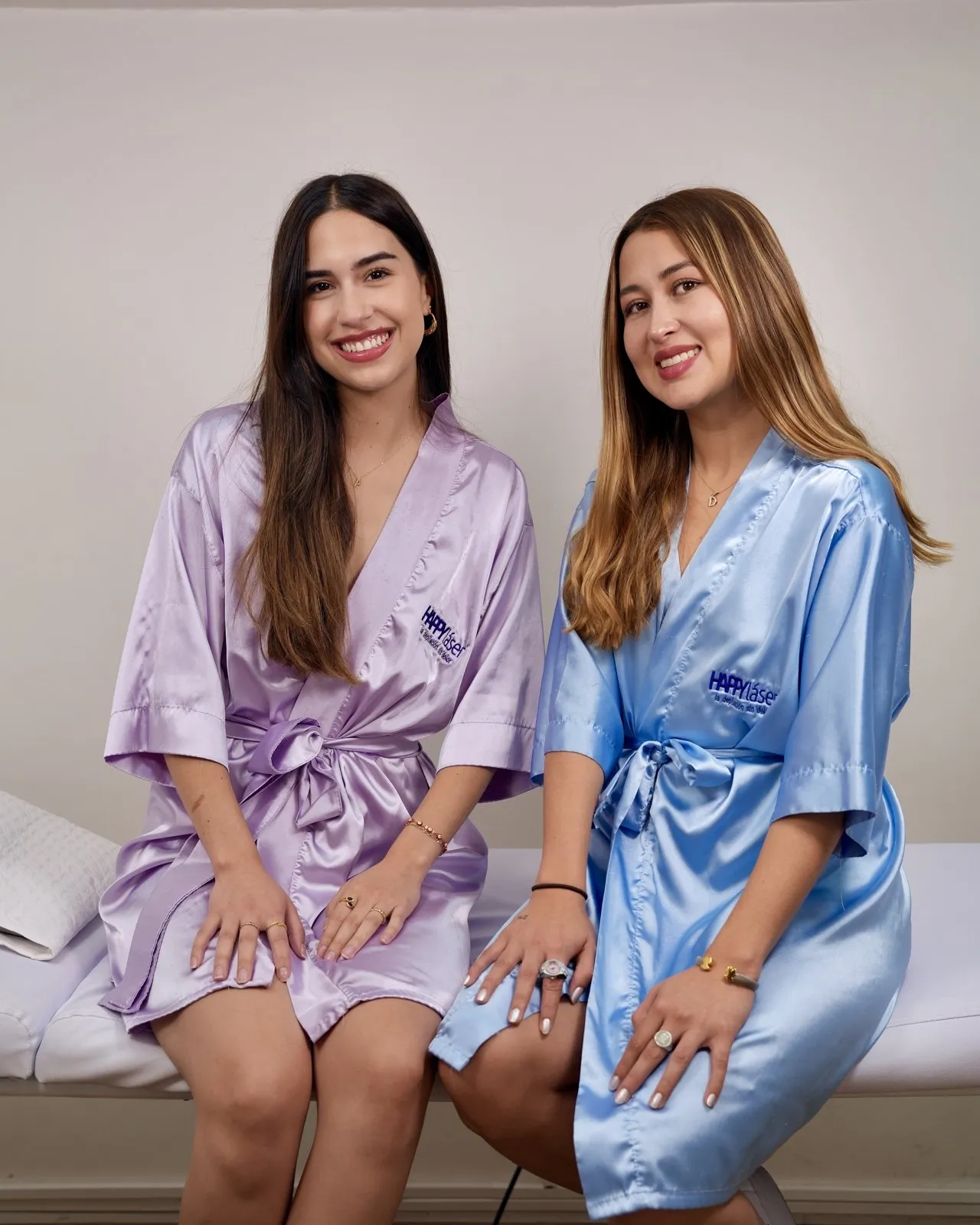 Dos clientas de HAPPYláser con batas, sonrientes, en una de nuestras sedes