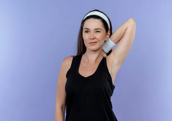 Mujer sonriente mostrando la axila depilada