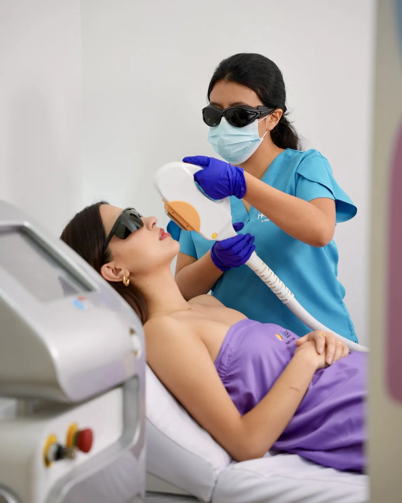 Técnica de HAPPYláser con gafas y mascarilla aplicando el láser en el rostro de una clienta